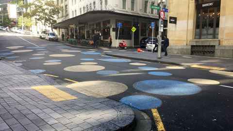 Blue and yellow polka dots painted on a road.