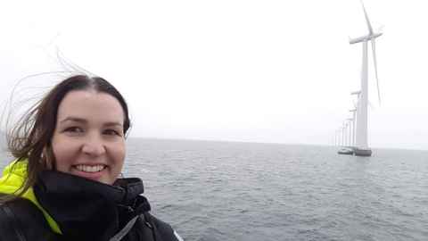 The image shows Dr Julie MacArthur at Denmark's Middlegrunden offshore windfarm, co-owned by a  Copenhagen city-owned utility and the Middlegrunden Co-operative. Photo: Julie MacAthur