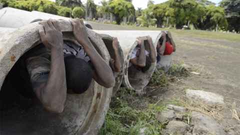 People in large concrete pipes.
