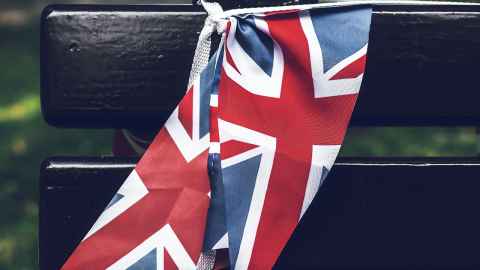 A Union flag draped over a park bench.