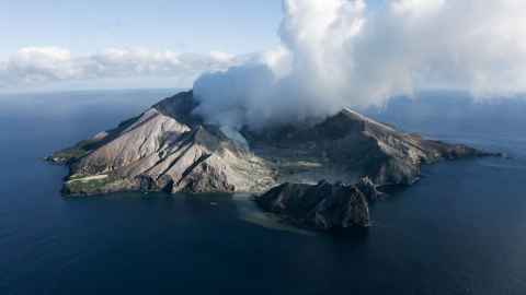Whakaari/White Island, with smoke coming from it.