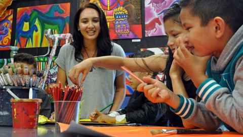 Children and a teacher in a classroom.