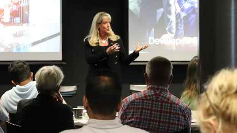 Jennifer Sepull presenting to a room of people.