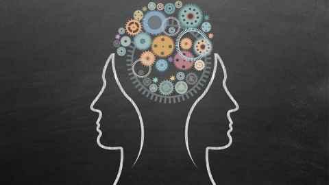 Two faces outline on either side of a single brain made up of cogs and gears.