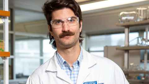 Dr Joel Rindelaub from the Faculty of Science in which white coat and glasses sporting a moustache and mullet. 