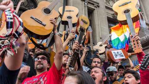 The photos shows protesors with guitars aloft: Thousands sang Victor Jara’s 'El derecho de vivir en paz' (The right to live in peace) when more than one million people took part in a street protest in Santiago in 2019. Photo: Wikicommons