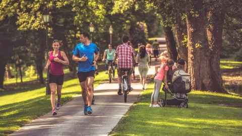 People running, walking and cycling in a park.