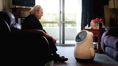 Woman in rest home with a robot