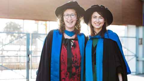 Two women in academic regalia.