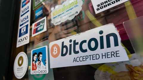 A sticker on a glass window indicating Bitcoin accepted here is shown at the entrance to a cafe in Zurich. Photo: iStock