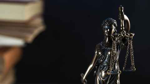 A statue of a woman wearing a blindfold, holding scales.