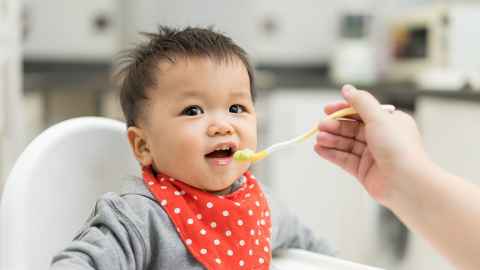 A baby being spoon-fed.