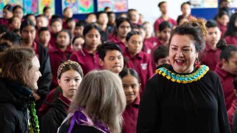 A woman in front of a group of school children.
