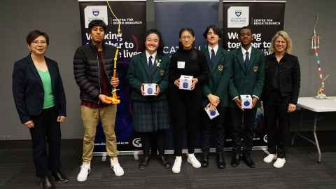 Teenagers in uniform, flanked by adults.