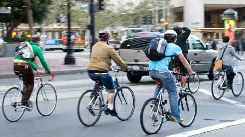 A group of people cycling down a city street.