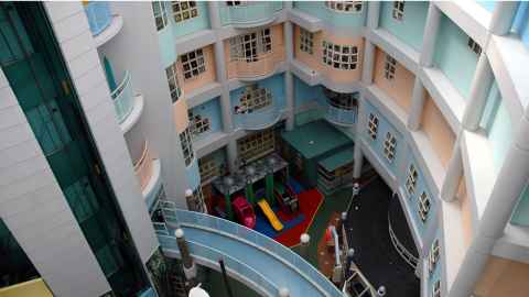 An interior courtyard of a brightly coloured building with a children's play area.