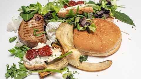 Food waste, including salad leaves, a hamburger bun and part of a banana.