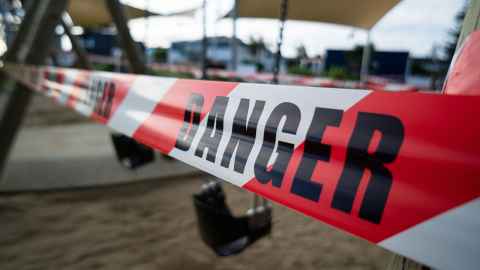 Red tape across a playground with 'danger' written on it.