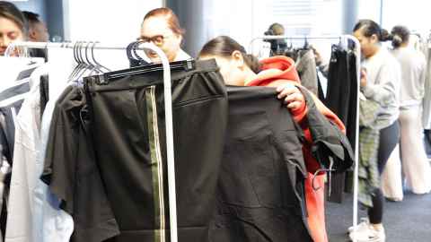 Women looking through racks of clothes.
