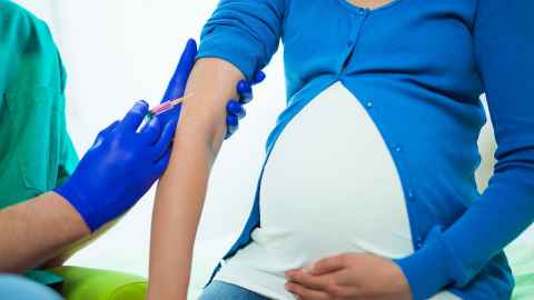 A pregnant woman receiving an injection.
