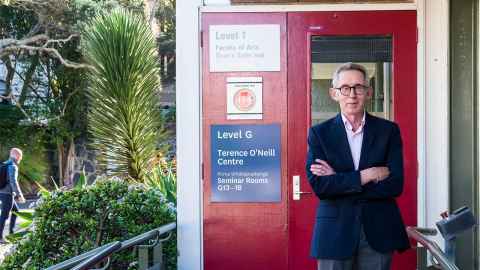 A man standing beside a sign that says ' Terence O'Neill Centre'.