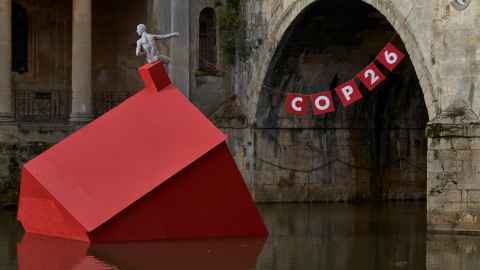 A half-submerged house and a banner for COP26.