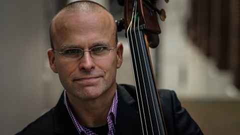 Olivier Holland holding a double bass.