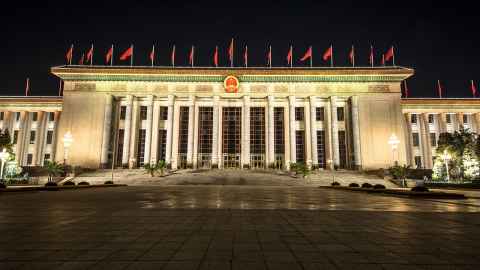 A large building with red flags along the roof.