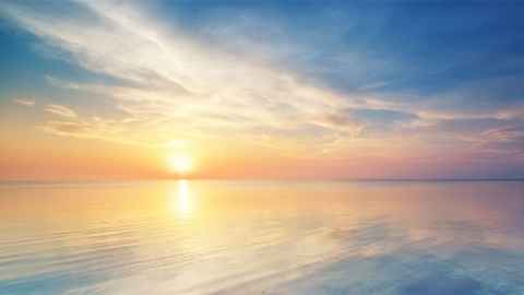 The sun rising over the ocean.