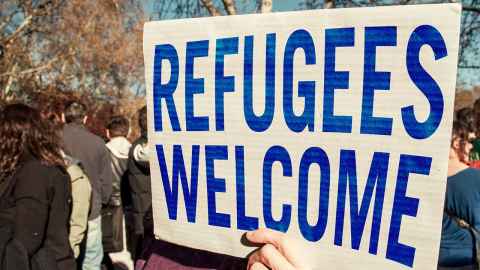 A sign reading 'Refugees welcome'.