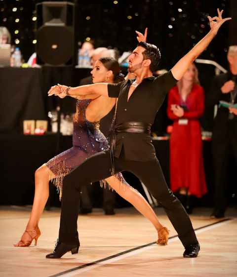 A couple in the middle of a ballroom dance.