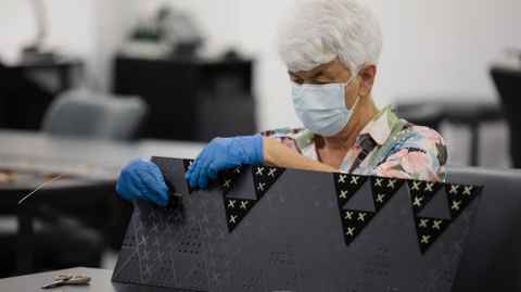 Dr Maureen Lander, an artist and alumna, works on her installation in the Engineering atrium in February 2022.