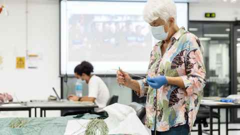 Artist Maureen Lander working on an installation in the Engineering atrium in February 2022. 