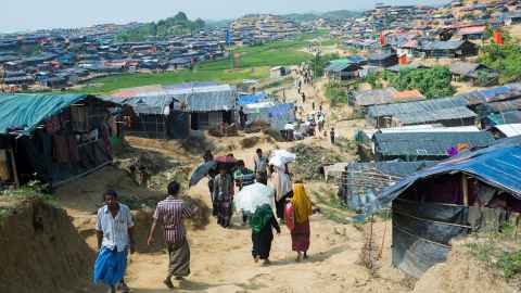 A crowded refugee camp with rough shelters.