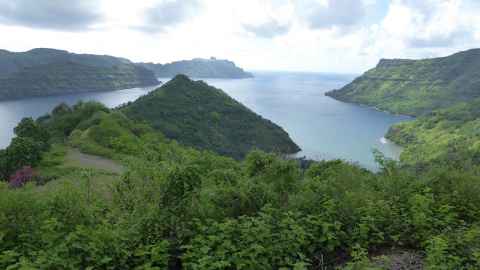 Hills covered in tropical green vegetation and blue sea.