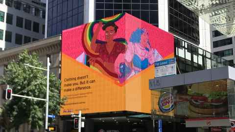 A colourful billboard on the corner of a city building.