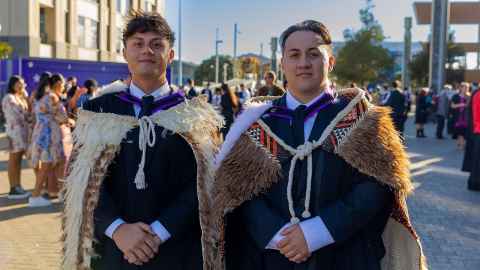 Two young men in purple engineering regalia, complete with korowai.
