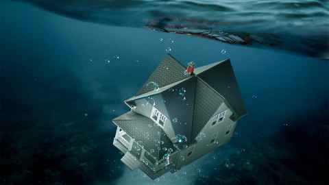 A house in the ocean, sinking below the surface.