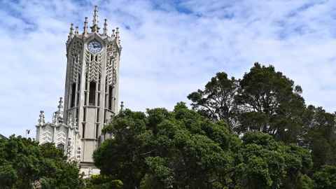 The ClockTower on a fine day, flanked by trees.