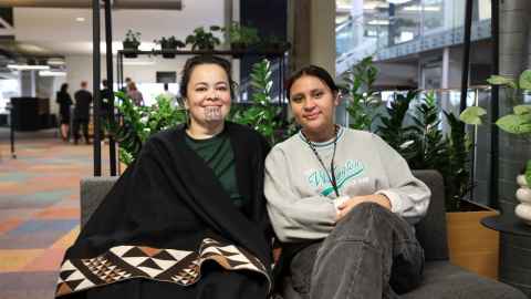 Elisapeta Heta and scholarship recipient Te Hekenga Hiwa Piahana sitting on a couch and smiling