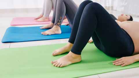 Three women lying on yoga mats.