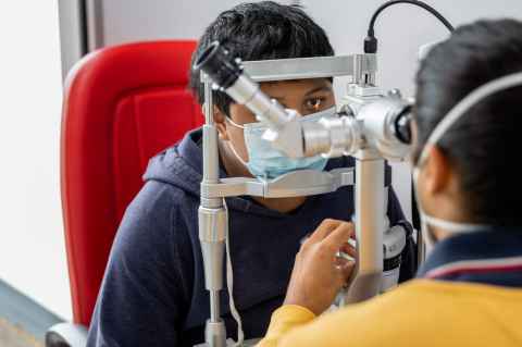 Veeran checks the eyes of a Fairburn School student.