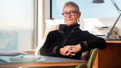 Emeritus Professor Jane Kelsey sitting at a desk