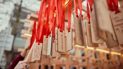 Wooden tags hanging from red ribbons.