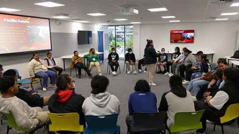 A group of about 20 people, sitting in a circle.