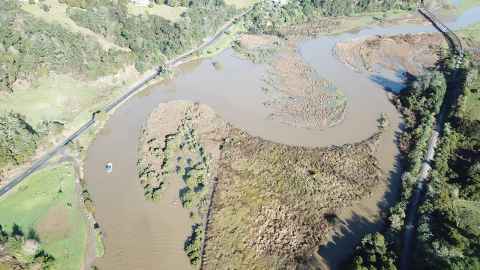 A brown river from above - a white boat can just be seen.