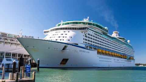 A large cruise ship with the name 'Explorer of the Seas' on the side, docked.