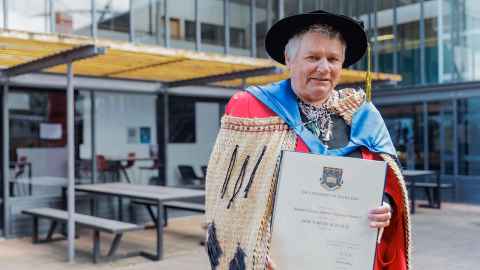 Dr Ramari Stewart holding her doctorate