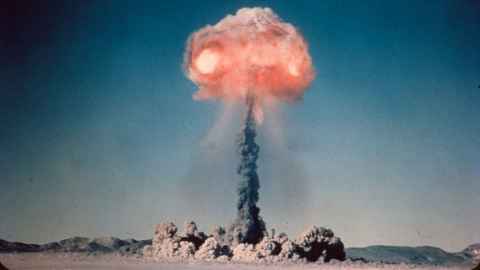 The mushroom cloud from a nuclear bomb detonated in a desert.