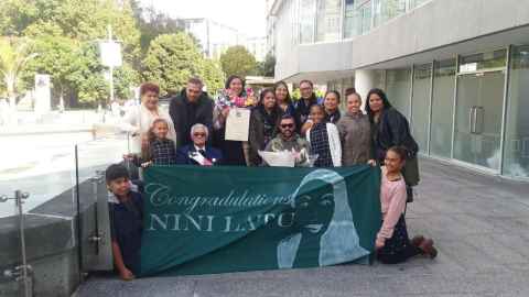 A group holding a banner that reads 'Congratulations Nini Latu'.